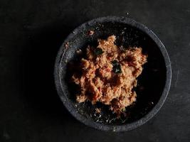 el coco rallado se mezcla con especias que consisten en ajo, chile, azúcar, azúcar de palma, sal y hojas de lima. foto