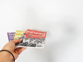 A hand is holding some Intisari magazines photo