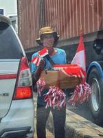 A hawker is selling red and white flags in August. photo