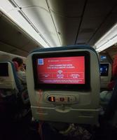 The interior of the passenger seat of a Turkish Airlines plane that has a touch screen for in-flight entertainment. photo