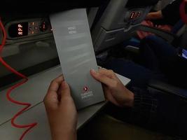 Turkey in July 2022. Two hands are holding a flight meal menu from Turkish Airline. photo