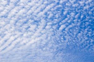 nubes blancas como la forma de una ola de mar en el cielo azul claro como fondo. foto