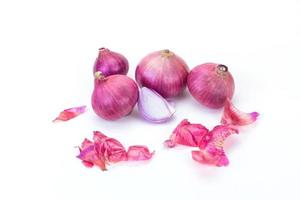 Shallots and pieces of peel are put on white table as background. It is a Thai onion, Thai herb. photo