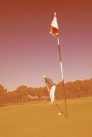 golf player hitting shot at sunny day photo