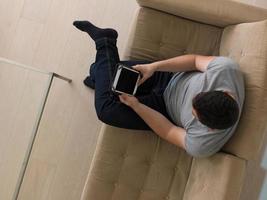 man on sofa using tablet computer photo