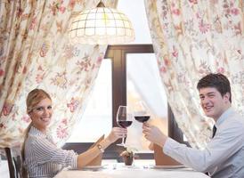 young couple having dinner at a restaurant photo