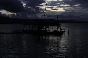 silueta de una cabaña de pesca tradicional junto al lago foto