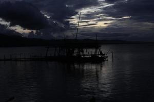 silueta de una cabaña de pesca tradicional junto al lago foto