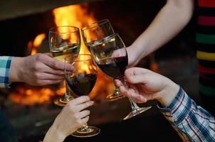 Young romantic couple sitting on sofa in front of fireplace at home photo