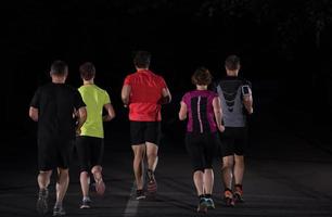 equipo de corredores en el entrenamiento nocturno foto