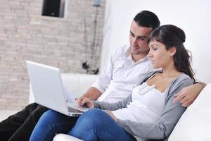 joyful couple relax and work on laptop computer at modern home photo