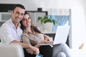 joyful couple relax and work on laptop computer at modern home photo