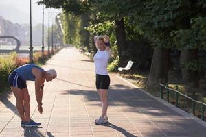 pareja calentándose y estirándose antes de trotar foto