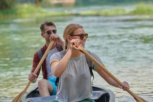 friends are canoeing in a wild river photo