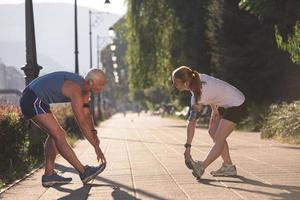 couple warming up and stretching before jogging photo