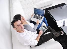 joyful couple relax and work on laptop computer at modern home photo