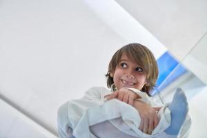 Portrait of arabian kid wearing traditional clothes sitting on the glass floor photo