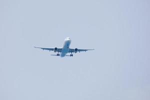 commercial aircraft flying under blue skies and arriving at the airport photo