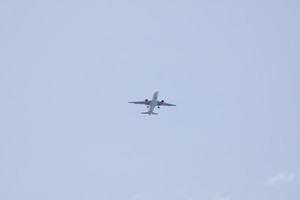 commercial aircraft flying under blue skies and arriving at the airport photo