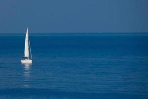 Solitary sailboat on the mediterranean coast of the Catalan Costa Brava photo