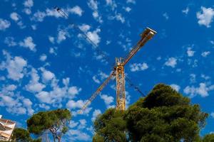 cranes working on a construction site under the blue sky photo