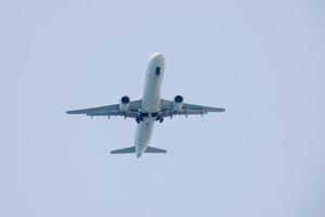 commercial aircraft flying under blue skies and arriving at the airport photo