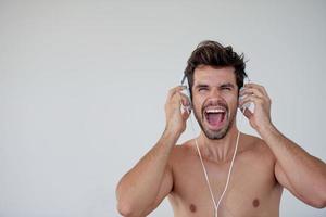 apuesto joven escuchando música en los auriculares foto