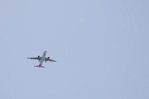 commercial aircraft flying under blue skies and arriving at the airport photo