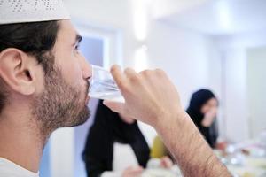 Muslim family having Iftar dinner drinking water to break feast photo