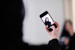 mujer musulmana tomando una foto selfie en casa