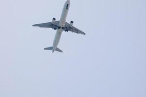 commercial aircraft flying under blue skies and arriving at the airport photo