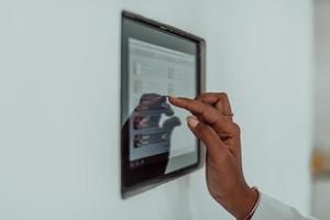 African woman using smart home screen control system photo
