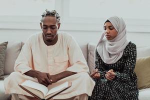 African Muslim couple at home in Ramadan reading Quran holly Islam book. photo