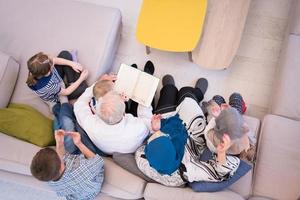 top view of modern muslim grandparents with grandchildren reading Quran photo