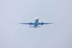 commercial aircraft flying under blue skies and arriving at the airport photo