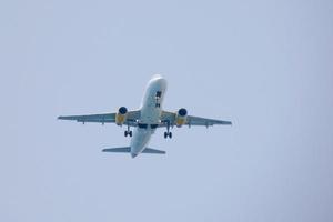 commercial aircraft flying under blue skies and arriving at the airport photo