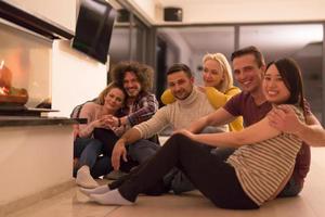 parejas multiétnicas sentadas frente a la chimenea foto