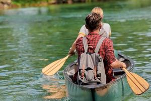 friends are canoeing in a wild river photo