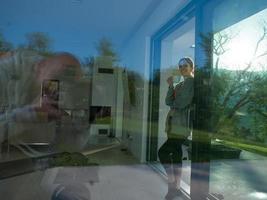 woman drinking coffee in front of her luxury home villa photo