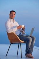 relaxed young man at home on balcony photo