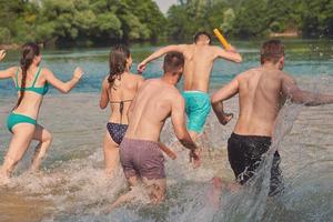 grupo de amigos felices divirtiéndose en el río foto