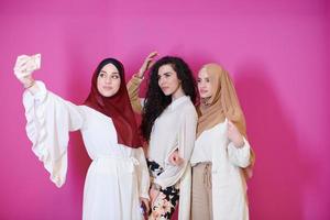 muslim women taking selfie picture isolated on pink photo