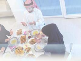 traditional muslim family praying before iftar dinner photo