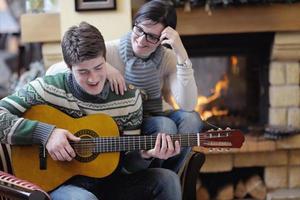 Young romantic couple sitting and relaxing in front of fireplace at home photo