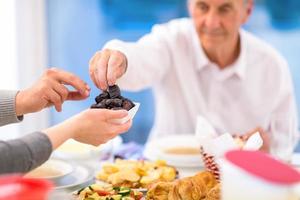 modern multiethnic muslim family sharing a bowl of dates photo