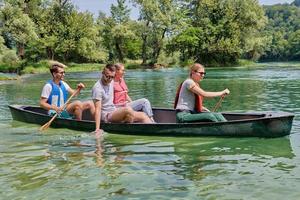 grupo de amigos exploradores aventureros están navegando en canoa en un río salvaje foto