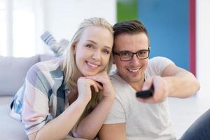 Young couple on the sofa watching television photo