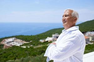 senior man in front of modern home photo