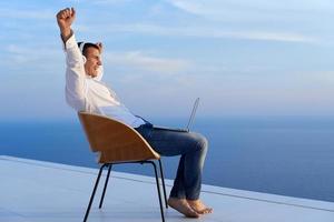 relaxed young man at home on balcony photo