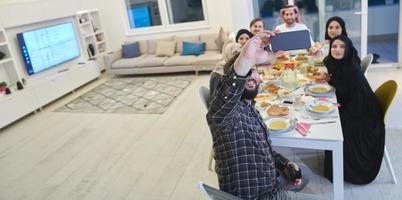 familia musulmana tomando selfie mientras tienen iftar juntos durante el ramadán foto